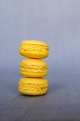 Stack of fresh delicious  lemon flavour yellow macarons on grey background. French pastry, sweet food