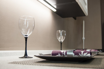 two empty glasses, plates and napkins on the tabletop prepared for lunch or dinner