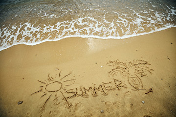 Summertime drawings in the sand - enjoying on a sandy beach.