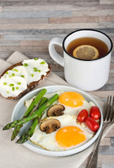 Breakfast. Scrambled eggs, asparagus, champignons, cherry tomatoes, sandwich and lemon tea.