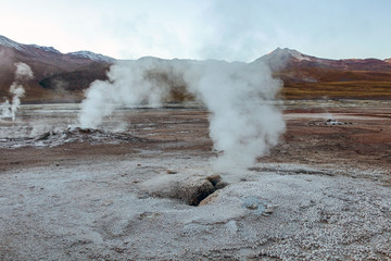 Erupting Hot Geyser Of Steam in El Tatio Geysers field at early morning sunrise, Atacama desert, Chile