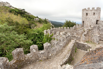 Fototapeta na wymiar Walls and stone towers of the 8th century The Moorish Castle over town Sintra. Historical landscape in Portugal and a UNESCO world heritage site