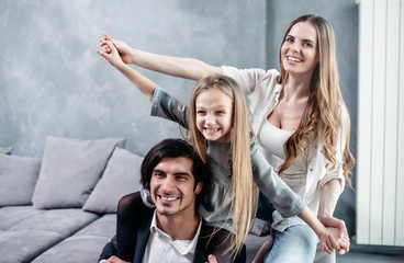 Happy little girl play with her mother and father