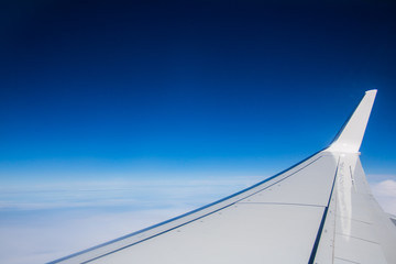 Fototapeta premium Blick über den Wolken aus Flugzeug ins blauen Himmel