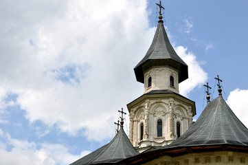 Bottom view of church turrets with crosses on cloudy sky background.