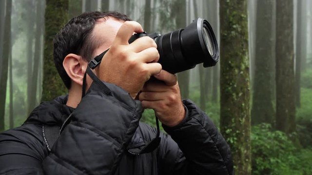 Young Caucasian Male Photographer Visit Alishan Scenic Area Taking Pictures of Forest with Mist, Haze and Fog in Taiwan