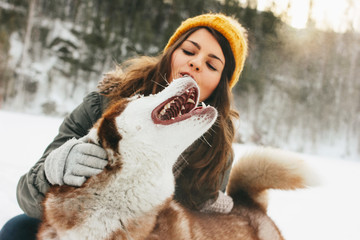 Red dog husky with his mistress brunette girl in forest outdoors in the cold season