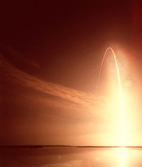 Launch of missile. Rocket is rising into starry sky. Red atmosphere. Elements furnished by NASA.