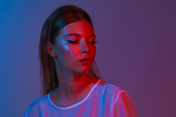 Neon close up portrait of young woman. Studio shot. Model posing in purple, red and pink lights....