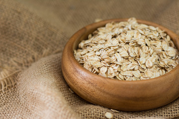 Oatmeal in a wooden bowl on a wooden table