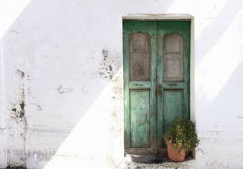 Antike grüne Eingangstür mit Pflanze vor Shabby Chic Fassade - Antique green front door with plant in front of shabby chic facade