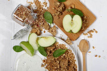 Healthy breakfasts of granola, yogurt and apples on a white background. View from above. Flat lay, top view. Still life concept.Horizontal photo.