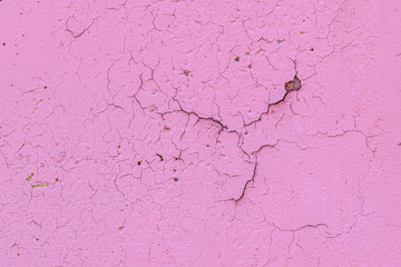Fragment of an old decayed wall. The cracked pink plaster. Soft focus.