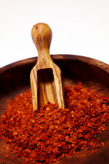 Rotes Chili Chilipulver in einer Holzschale und Gewürzschaufel