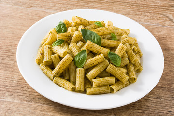 Penne pasta with pesto sauce on wooden table