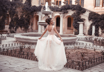 Beautiful bride in pink wedding dress. Outdoor romantic portrait of attractive brunette woman with...