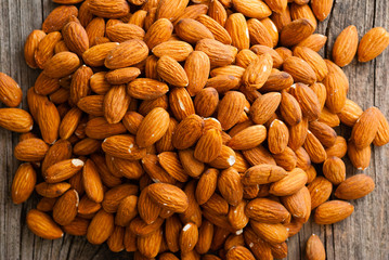 peeled almonds on old wooden table, top view