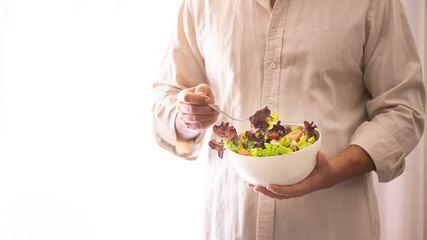 Obraz na płótnie Canvas Man hands holding a green salad. Healthy lifestyle and vegetarian vegan concept.