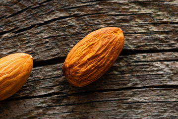 two peeled almonds on old wood table