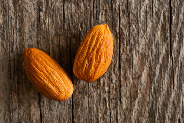 two peeled almonds on old wood table