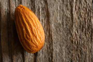 one peeled almond on old wood table