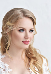 Beautiful bride with fashion wedding hairstyle - on white background.Closeup portrait of young gorgeous bride. Wedding. Studio shot.Beautiful bride portrait with veil over her face