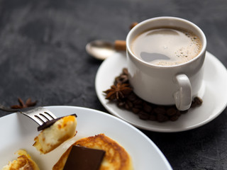 white Cup of espresso and cheese pancakes with bitter chocolate
