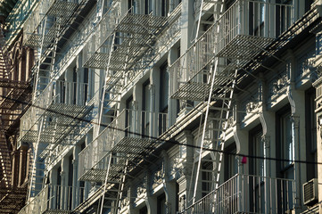 Traditional downtown New York City architecture featuring industrial facades lined with metal fire escapes in the SoHo-Cast Iron Historic District, Lower Manhattan