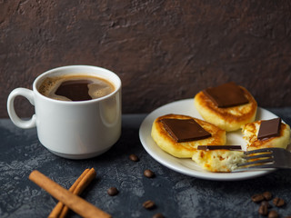 white Cup of espresso and cheese pancakes with bitter chocolate