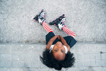 Tired female with roller skates lying on road