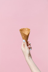 Woman holding waffle cones on color background.