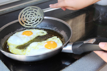 Friendo huevos en sartén.