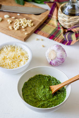 Pesto sauce and ingedients on a white background. Italian cuisine. Vegetarian food. The diet.