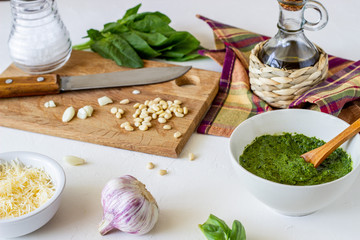 Pesto sauce and ingedients on a white background. Italian cuisine. Vegetarian food. The diet.