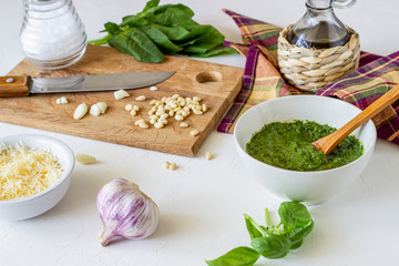 Pesto sauce and ingedients on a white background. Italian cuisine. Vegetarian food. The diet.