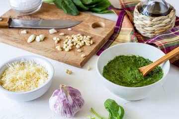 Pesto sauce and ingedients on a white background. Italian cuisine. Vegetarian food. The diet.