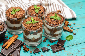 Classic tiramisu dessert in a glass on blue wooden background
