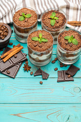 Classic tiramisu dessert in a glass on blue wooden background