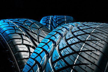 Row of car tires with a profile close-up on a black background