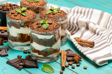 Classic tiramisu dessert in a glass on blue wooden background