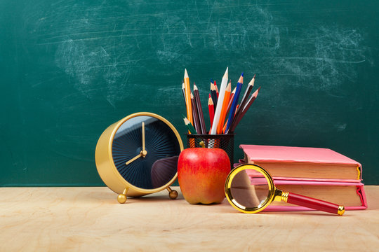 Red Apple On A Pile Of Books, Paper And Pencil On The Desk