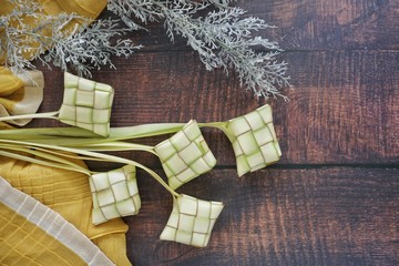 Ketupat (Rice Dumpling) On Wooden Background. Ketupat is a natural rice casing made from young coconut leaves for cooking rice during eid Mubarak, Fitri 