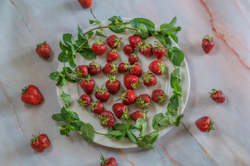 Strawberries and mint dish on marble background