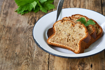 Slices of homemade banana bread in a white plate on a wooden table