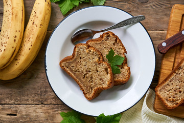 Slices of homemade banana bread in a white plate on a wooden table