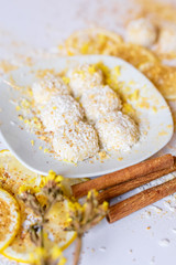 White chocolate truffles with coconut and cinnamon on white background
