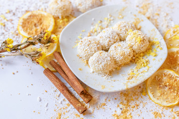 White chocolate truffles with coconut and cinnamon on white background