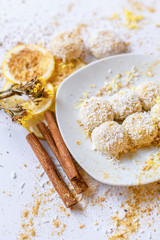 White chocolate truffles with coconut and cinnamon on white background