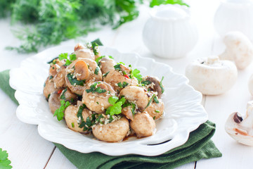 Marinated champignons with spices, herbs and sesame on a white plate, horizontal