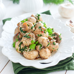 Delicious marinated mushrooms in a beautiful bowl with onions, pepper, dill and olive oil on a gray-blue background, top view, champignons